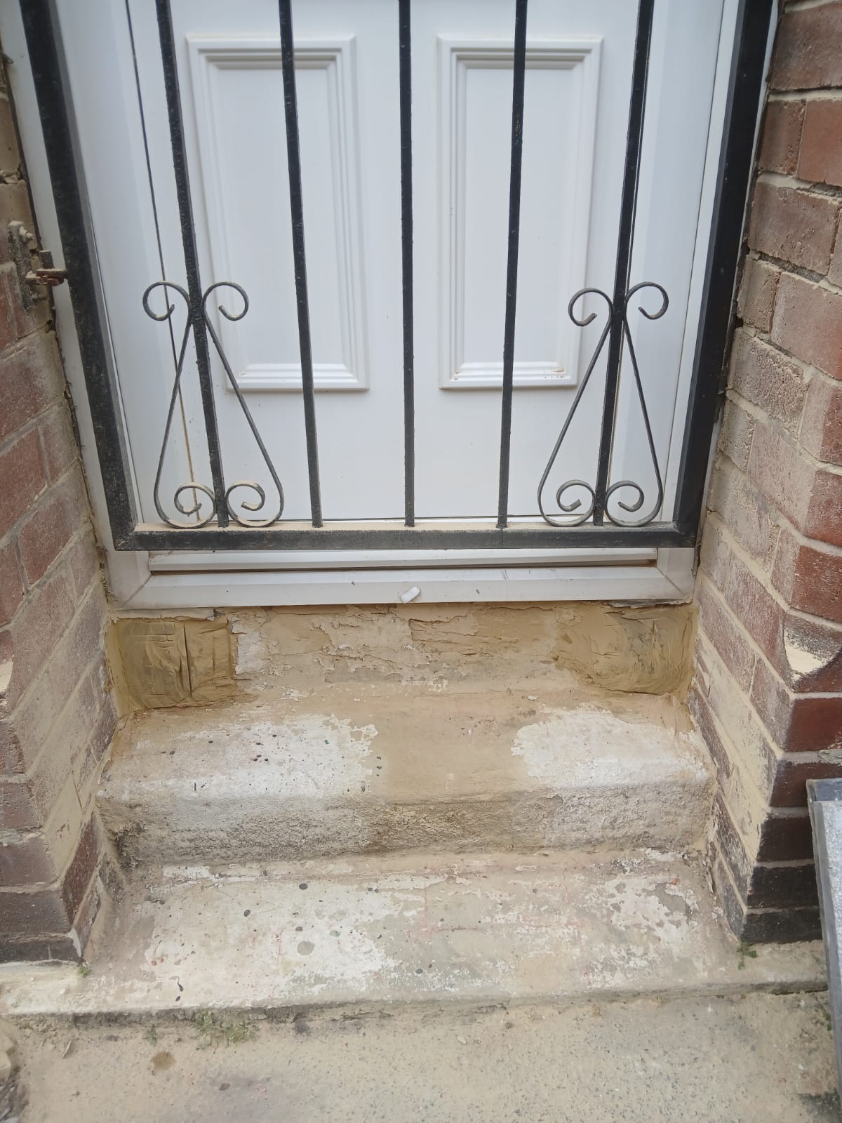 Front doorstep with fresh render and repair work around the threshold