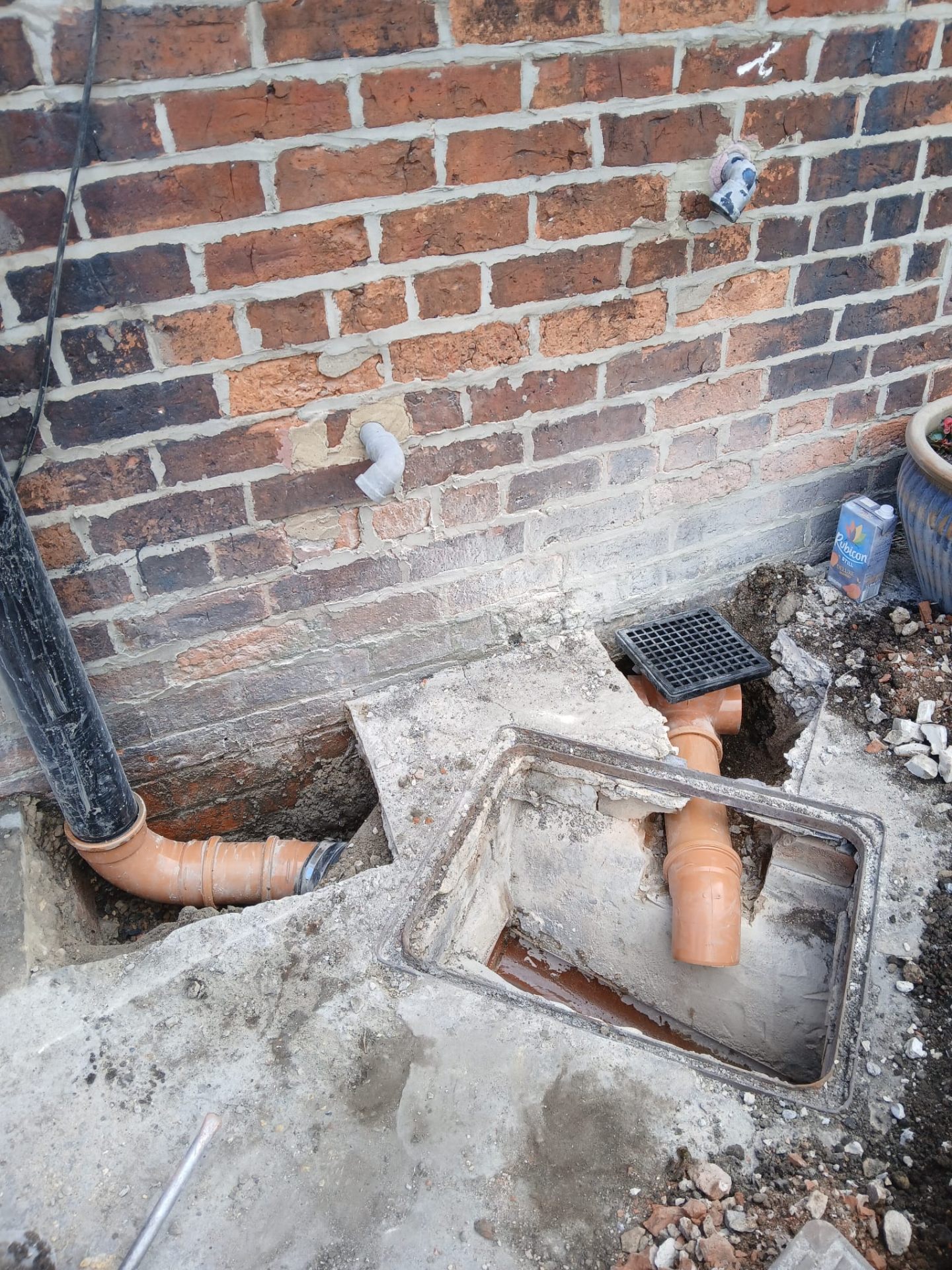 New external gully and inspection chamber installation against brick wall
